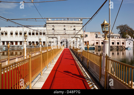 Tappeto rosso e oro ringhiere all'ingresso passerella per la Shree Durgiana tempio indù, Amritsar Punjab, India Foto Stock