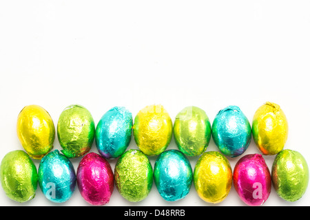 Foglio colorato avvolto le uova di pasqua Foto Stock