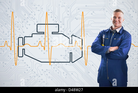 Meccanico con orgoglio in piedi nella parte anteriore del motore sullo sfondo Foto Stock