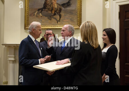 Vice Presidente USA Joe Biden giura il nuovo direttore della CIA John Brennan nella sala Roosevelt della Casa Bianca. Brennan ha prestato giuramento con la sua mano su un originale progetto di Costituzione che ha George Washington di scrittura personale e annotazioni su di esso, risalente al 1787. I membri di Brennan la famiglia stare con lui. Foto Stock