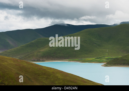 Lago tranquillo in un paesaggio collinare sotto un cielo nuvoloso;Shannan xizang cina Foto Stock