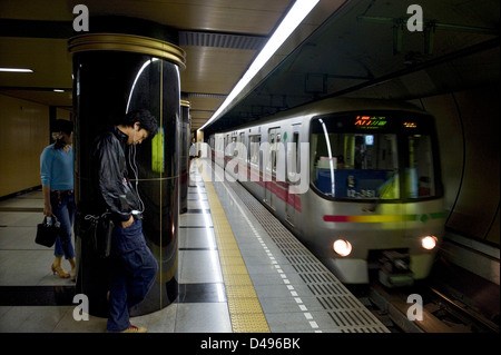 I passeggeri in attesa per la metropolitana treno arrivando alla piattaforma della metropolitana di Tokyo Metro Railway transportation system in Giappone Foto Stock