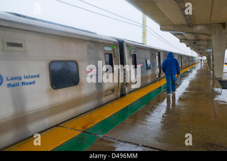 Merrick, New York, Stati Uniti d'America. 8 marzo 2013. Sebbene il Long Island Rail Road pianificare rimane buona malgrado né'Pasqua viscido nevicata venerdì pomeriggio sulla costa sud di Long Island, il freddo umido venti raggiungono anche i passeggeri in attesa sotto la sporgenza di protezione al di sopra della piattaforma degli elevati Merrick stazione ferroviaria. Credito: Ann e Parry / Alamy Live News Foto Stock