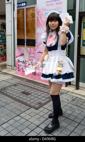 Ragazze vestite di cameriera francese costumi distribuivano buoni sconto per Maid Cafe di Tokyo di Akihabara il quartiere del divertimento. Foto Stock