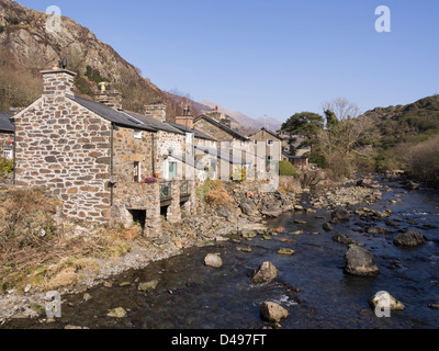 Riverside villette a schiera con piccolo giardino posteriore supporto sullo Afon Glaslyn fiume in Snowdonia. Beddgelert Gwynedd North Wales UK Foto Stock