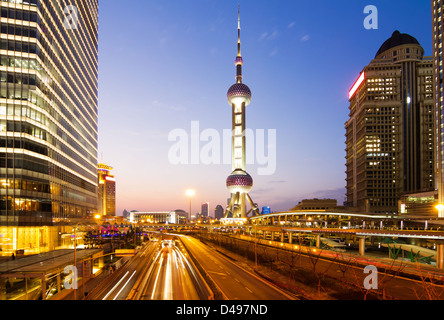 Sentieri di luce sulla strada con un edificio moderno sfondo in shanghai, Cina Foto Stock