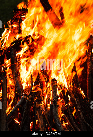 La masterizzazione di bastoni impilati fino a costruire un tradizionale campo di fuoco con fiamme di grandi dimensioni Foto Stock