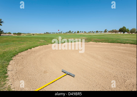 Bunker trappola di sabbia su un campo da golf con il verde della distanza Foto Stock