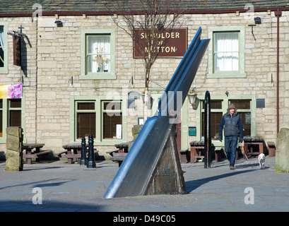 L'uomo - e il cane - a piedi attraverso St George Square in Hebden Bridge, Calderdale, West Yorkshire, Inghilterra, Regno Unito Foto Stock