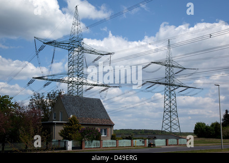 Pubblicizzare, Germania, casa prima di tralicci di energia elettrica Foto Stock