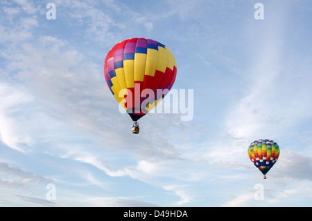 Due i palloni ad aria calda galleggiante attraverso nuvole bianche in un cielo blu. Foto Stock