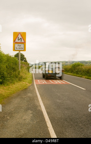 Un 4x4 veicolo viaggia veloce lungo un paese britannico strada a velocità verso una curva in strada. Foto Stock