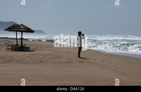 Sardegna, Italia, una donna sulla spiaggia di Costa Verde fotografato le onde Foto Stock