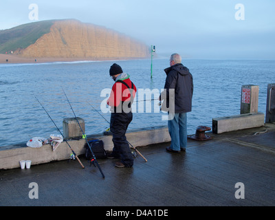 I pescatori alla fine del molo t West Bay, Bridport,Dorset, Regno Unito Foto Stock