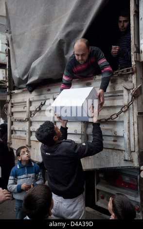 Aleppo, Siria: persone distribuire15kg box di aiuti alimentari alle persone bisognose Bustan Al Qasr sezione di Aleppo, Siria Foto Stock