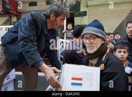 Aleppo, Siria: persone distribuire15kg box di aiuti alimentari alle persone bisognose Bustan Al Qasr sezione di Aleppo, Siria Foto Stock