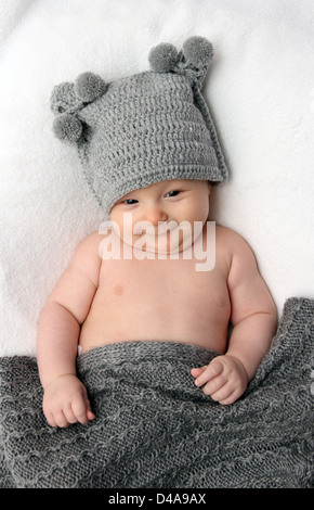 Bellissimo bambino in grigio berretto lavorato a maglia Foto Stock