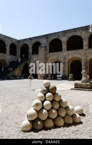 Rodi. La Grecia. Impilati mortaio di pietra sfere nel meraviglioso cortile interno del gotico cavalieri ospedale nella città vecchia. Foto Stock