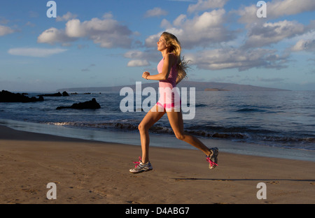 Un sano, montare la donna esercita presso la spiaggia di Wailea, Maui, Hawaii. Foto Stock