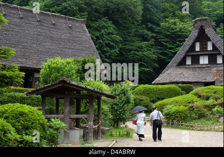 I visitatori a piedi passato kayabuki storico con tetto di paglia villaggio agriturismi presso la Nihon Minkaen open-air folk museum in Kawasaki Foto Stock