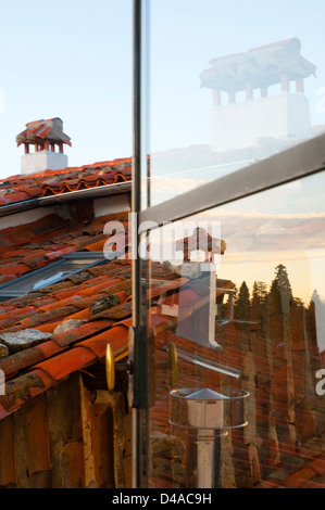 Camini e la sua riflessione sul vetro. Candelario, provincia di Salamanca, Castilla Leon, Spagna. Foto Stock