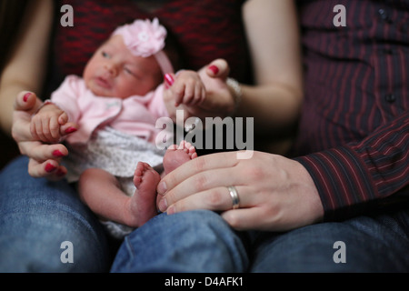 Un minuscolo neonato tenuto sulla sua madre giro. Foto Stock