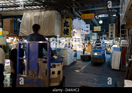 Carrelli motorizzati zip avanti e indietro all'interno dei corridoi di occupato a Tsukiji Commercio all'ingrosso Mercato del Pesce di Tokyo Foto Stock