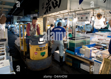 Carrelli motorizzati zip avanti e indietro all'interno dei corridoi di occupato a Tsukiji Commercio all'ingrosso Mercato del Pesce di Tokyo Foto Stock