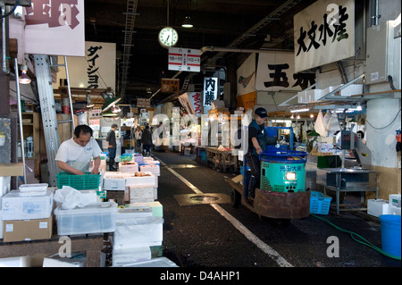 Carrelli motorizzati zip avanti e indietro all'interno dei corridoi di occupato a Tsukiji Commercio all'ingrosso Mercato del Pesce di Tokyo Foto Stock