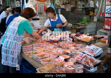 Un negozio di vendita al dettaglio la vendita di una varietà di piatti a base di frutti di mare nei pressi di Tsukiji Commercio all'ingrosso Mercato del Pesce di Tokyo. Foto Stock