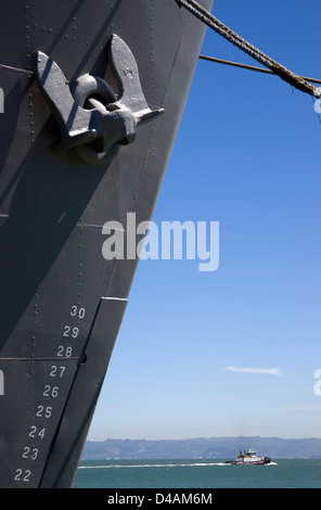 Composizione verticale della nave ormeggiata Bow e ancoraggio rimorchiatore che passa nel vano sottostante Foto Stock