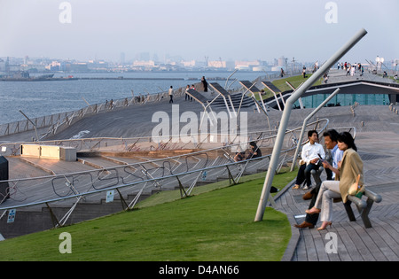 Le persone che si godono il parco-come teak listone falda di tetto di International Passenger Terminal al molo di Osanbashi sul lungomare di Yokohama Foto Stock