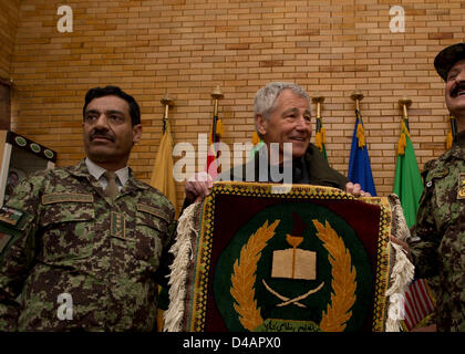 Il Segretario alla difesa degli Stati Uniti Chuck Hagel è presentato con un handmade tappeto afgano con il logo del militare di Kabul, centro di formazione degli afgani Brigadiere Generale Aminullah Patyani, comandante militare di Kabul, centro di formazione Marzo 10, 2013 a Kabul, Afghanistan. Hagel è in Afghanistan durante il suo primo viaggio come Segretario della Difesa a visitare le truppe degli Stati Uniti e la NATO e i leader afghani. Foto Stock