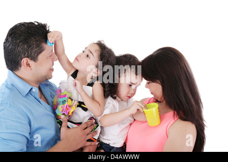 Ritratto di una bella famiglia giocando su bianco Foto Stock