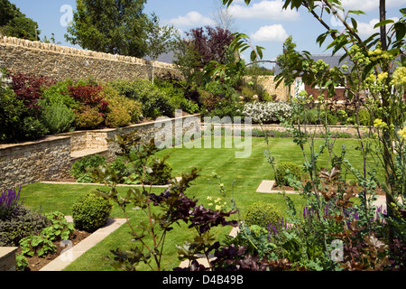 Giardini del Regno Unito. Un nuovo giardino con arbusti in confini e calcare nuove mura di cinta. Foto Stock