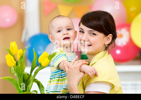 Bambina carina ragazza con la madre su sfondo di festa Foto Stock