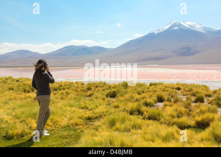 La ragazza che parla al telefono sulle rive della Laguna Colorada, Bolivia Foto Stock