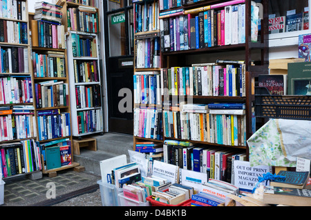 Libri impilati su ripiani al di fuori di una frantumazione bookshop. Foto Stock