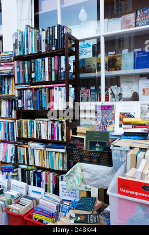 Libri impilati su ripiani al di fuori di una frantumazione bookshop. Foto Stock