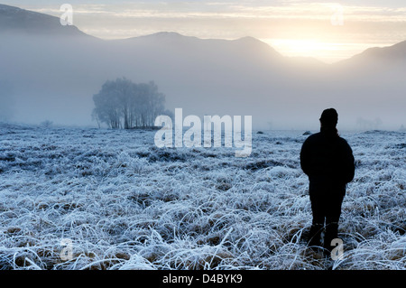 Una persona ammirando il gelido meteo a Glenfinnan nelle Highlands scozzesi Foto Stock