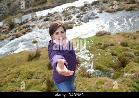 Giovane donna per chiedere aiuto a salire in montagna Foto Stock