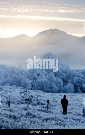 Una persona ammirando il gelido meteo a Glenfinnan nelle Highlands scozzesi Foto Stock