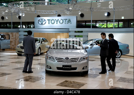 I potenziali acquirenti guardare oltre il modello più recente Toyota automobili sul display in showroom di Toyota Kaikan Centro Visitatori, Nagoya Foto Stock