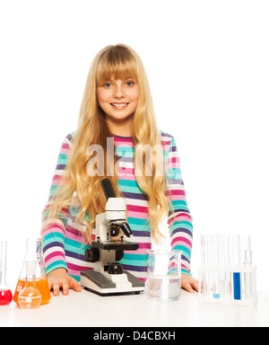 Bionda intelligente ragazza teen in laboratorio con microsope e attrezzature teset Foto Stock