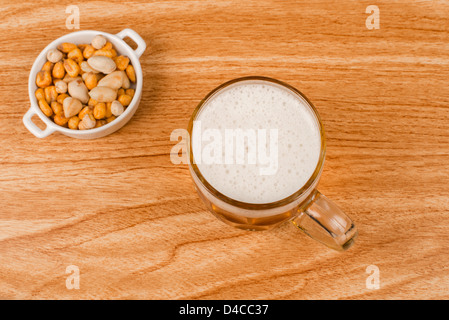 Angolo di alta vista di birra e un assortimento di dadi su un banco di bar Foto Stock