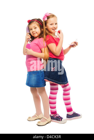 Due ragazze e caucasici Asian a giocare per essere grande come la madre e la spazzolatura che compongono il viso, isolato su bianco a piena lunghezza ritratto Foto Stock