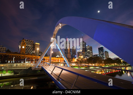 Southgate ponte illuminato al crepuscolo con lo skyline della città in background. Melbourne, Victoria, Australia Foto Stock