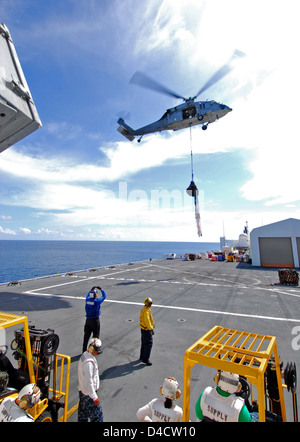 Un MH-60S Knighthawk elicottero conduce un rifornimento verticale (VERTREP) Foto Stock