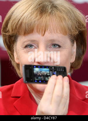 Il cancelliere tedesco Angela Merkel pone con un SonyEricsson telefono mobile alla fiera CeBIT di Hannover, Germania, 04 marzo 2008. Da 04 a 09 marzo, circa 5.500 espositori da 75 paesi in vetrina i loro prodotti più recenti presso la più grande fiera sul digitale e soluzioni di telecomunicazioni. Foto: KAY NIETFELD Foto Stock