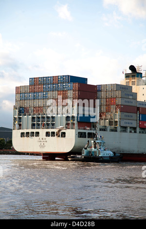 Tian Jin ha un design Panamax nave container essendo assistito a poppa da PB abbondanza rimorchiatore a Melbourne in Australia Foto Stock
